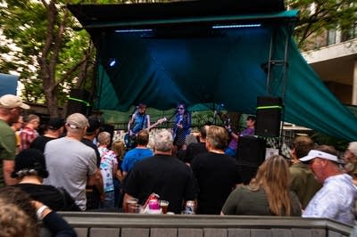 a rock band performing on an outdoor stage