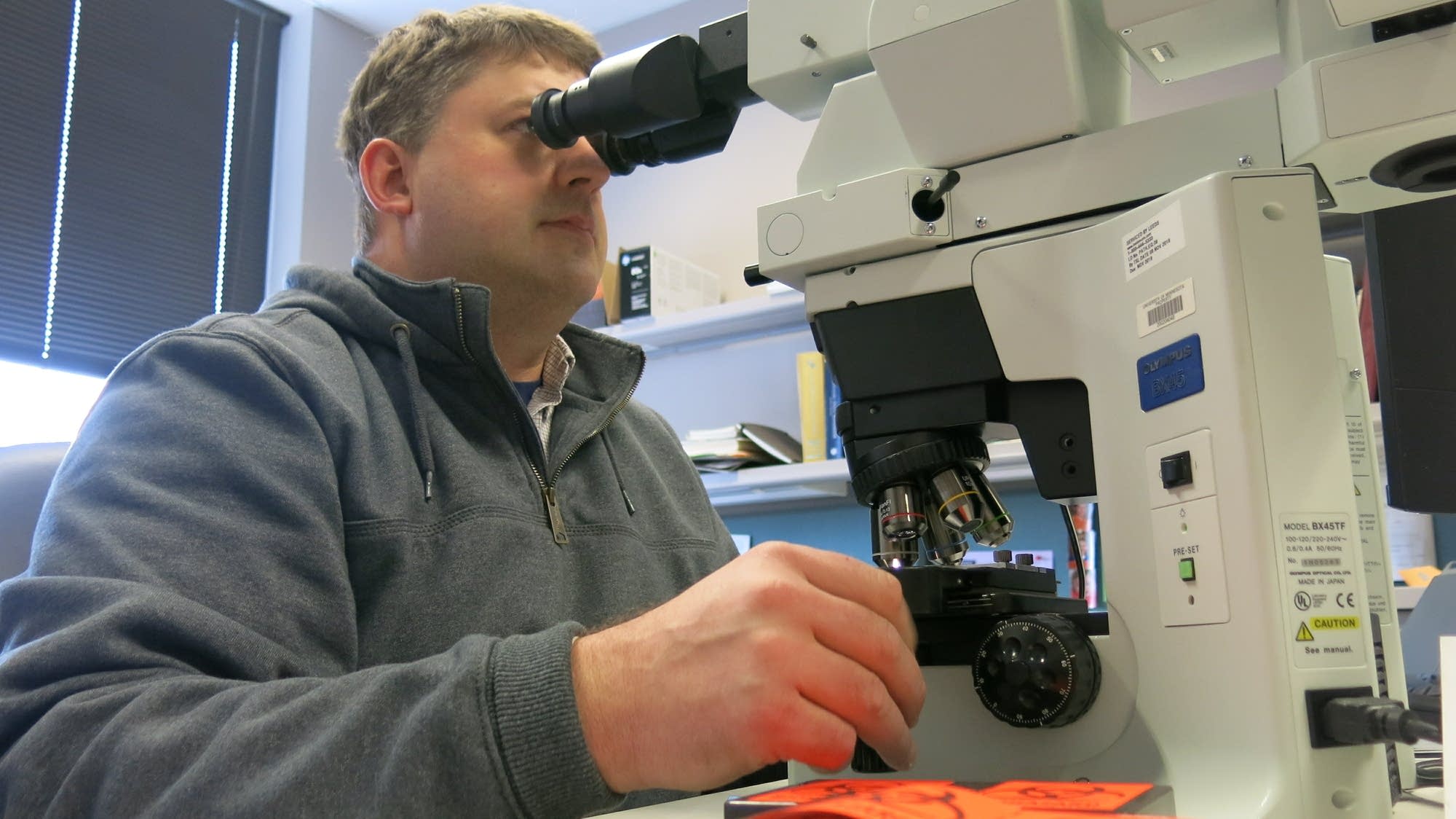 Schefer squints through a microscope, looking for any sign of CWD