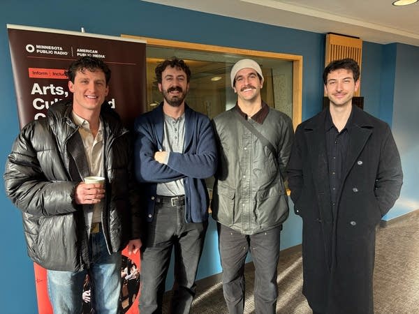 Four men stand together for a group portrait