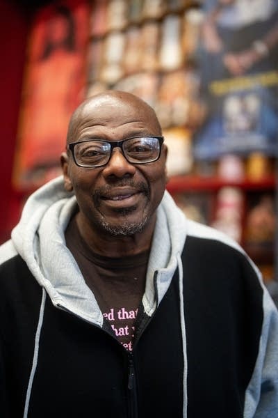 A man smiles for a photo inside a record store