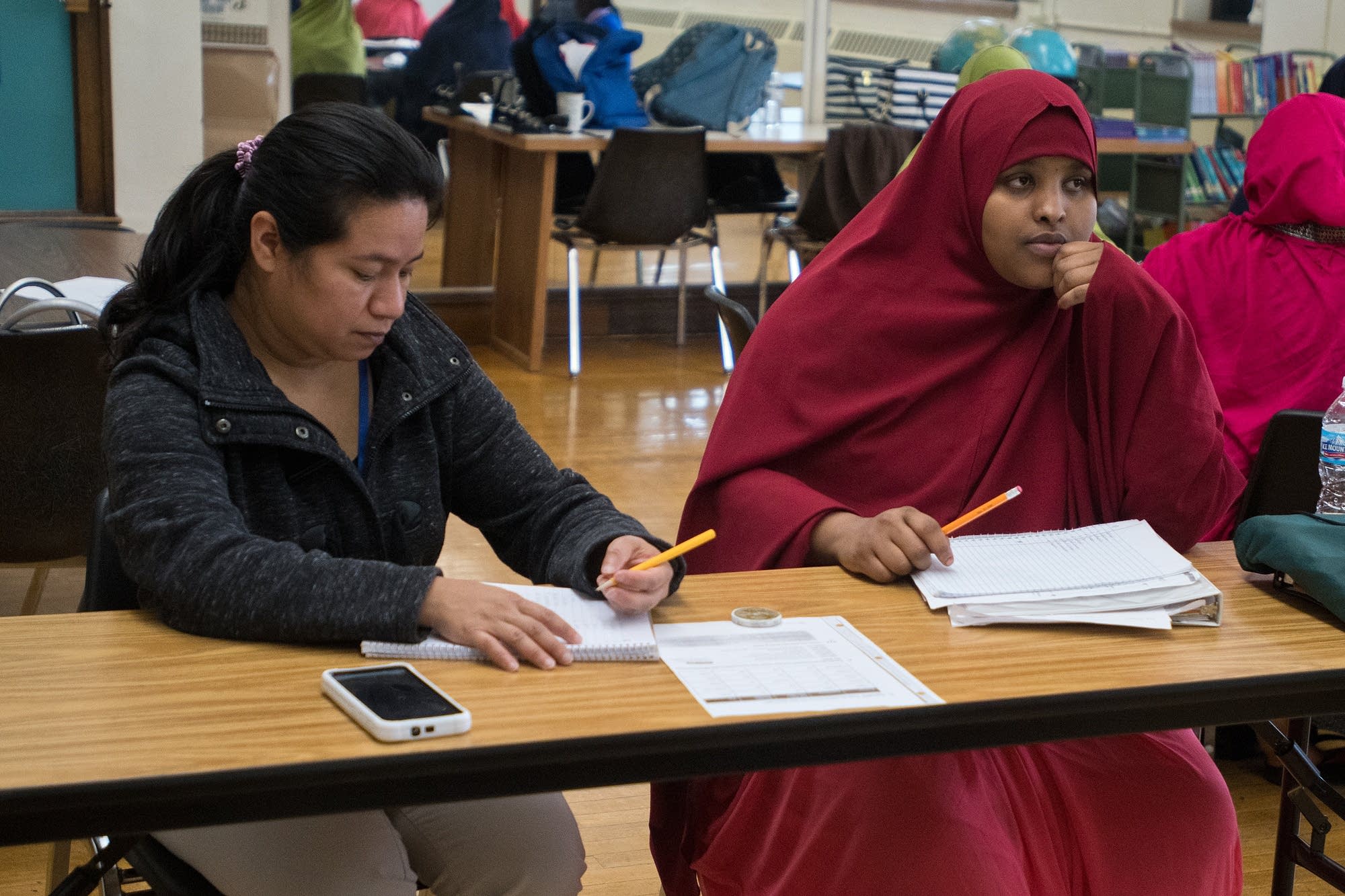 Muno Warsame and Julia Lopez take notes during an English class.