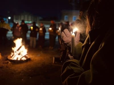 people standing outside with candles at vigil 