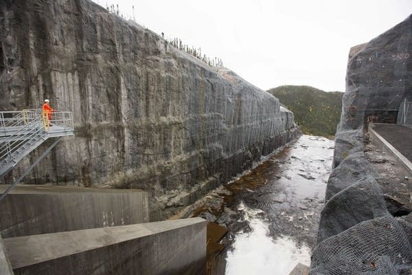 A Hydro-Quebec employee looks out over the spillway for Romaine 3 hydroelectric dam in the Côte-Nord Administrative Region of Quebec, Canada, on October 4, 2018. - On a frigid night, the roar of heavy machinery chipping away at rock echoes through Canada's boreal forest: in the far north of Quebec province, four massive hydroelectric dams that will produce power for US markets are nearing completion. (Photo by Lars Hagberg / AFP) / TO GO WITH AFP STORY by Clement SABOURIN        (Photo credit should read LARS HAGBERG/AFP via Getty Images)