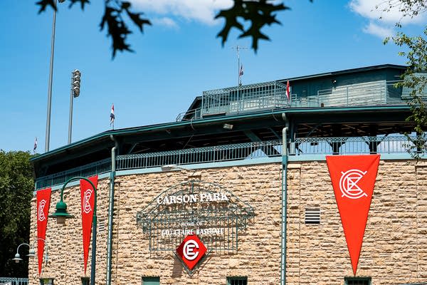 Exterior of a stone-faced ballpark festooned in festival pennants and banners