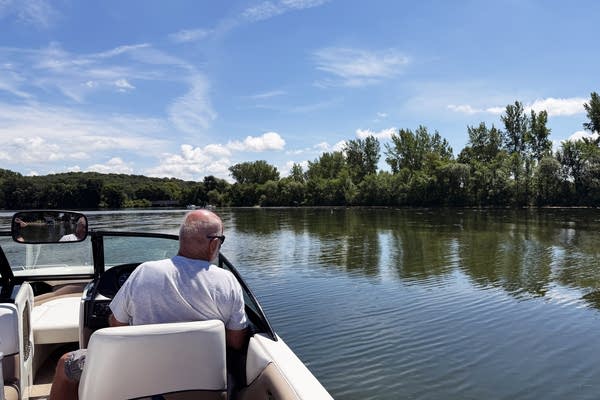 A man drives a boat on a lake