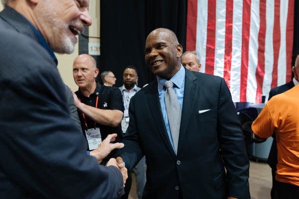 Two men shake hands backstage.