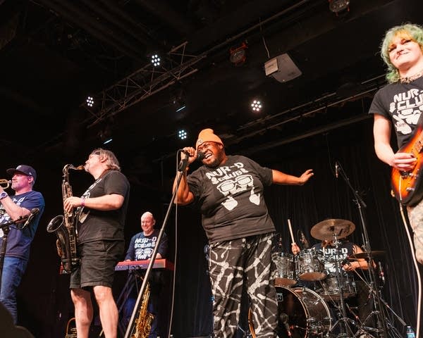 A hip-hop group performs onstage in a music venue