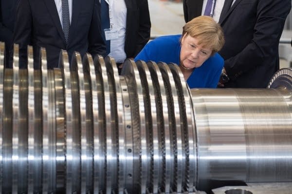 German Chancellor Angela Merkel examines a turbine at the Siemens plant in Goerlitz, eastern Germany.     (Credit: Getty Images).