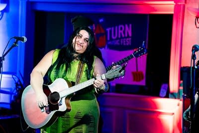 A musician plays guitar onstage