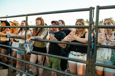 Music fans take in a performance from behind a livestock fence