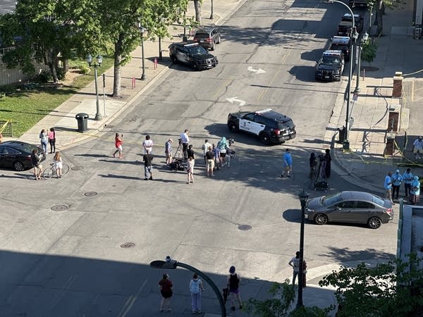 Aerial photos of police cars blocking a city street.