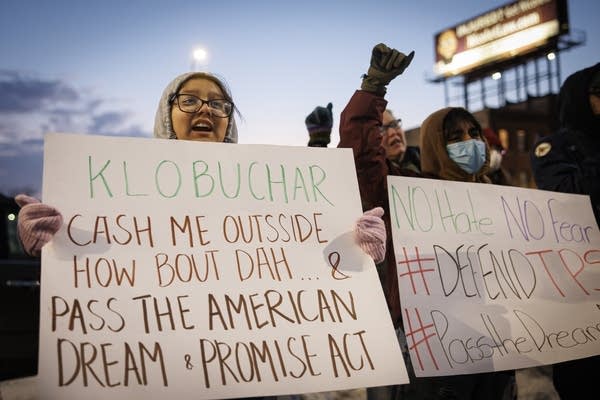 A person holds a sign 