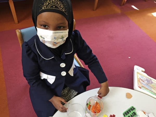 Amira Hassan, of Burnsville, wears a mask to protect her from measles.