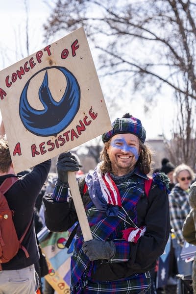 Someone holds a Rebel Loon sign