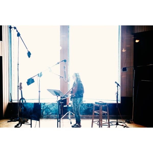 A musician sings in a recording studio