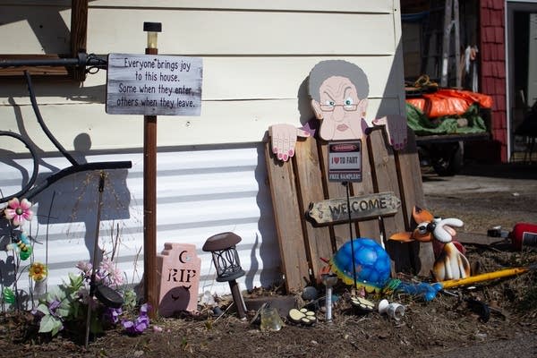 A collection of yard signs sit near a house.