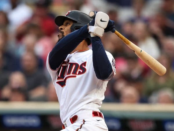 Buxton completes his swing and watching the ball fly away.