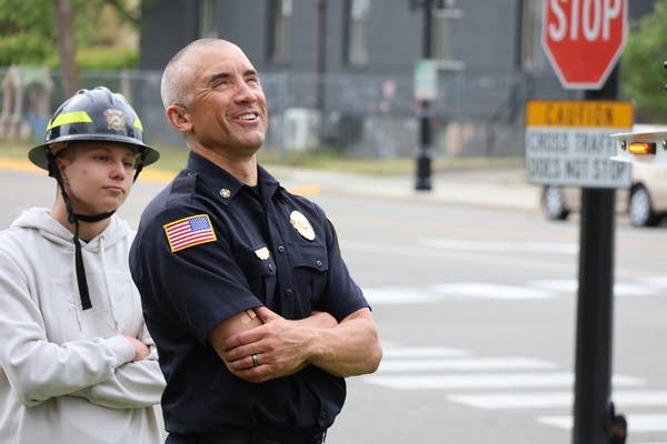 A fire chief and person wearing a fire helmet