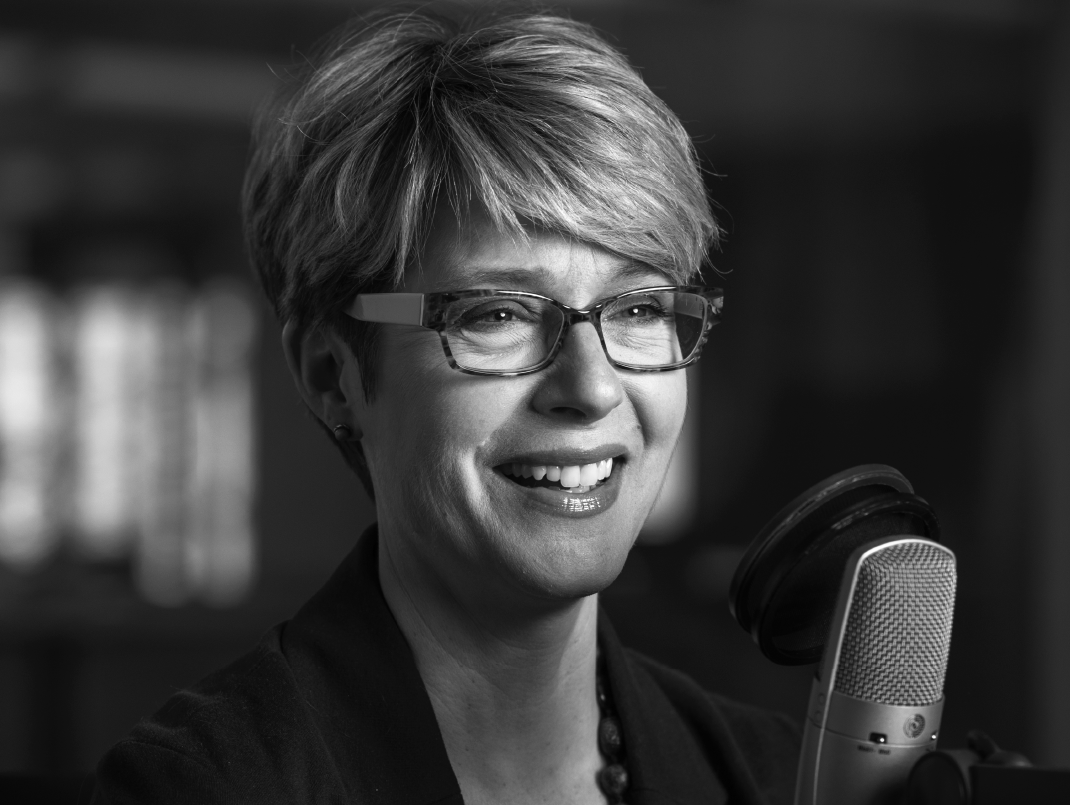 A woman smiling by a microphone