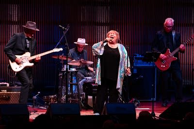 A band performing together onstage in a concert hall