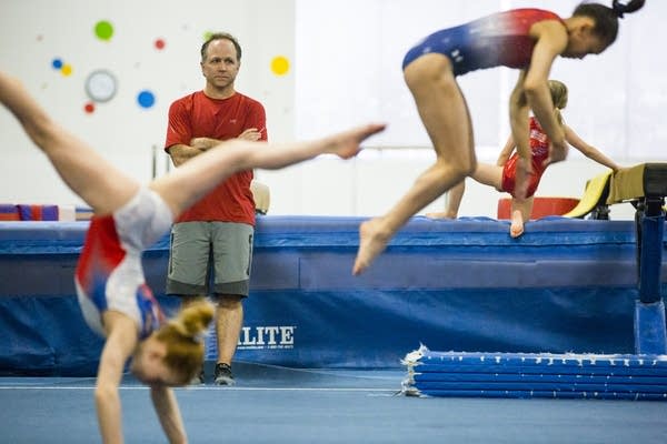 Coach Jess Graba watches gymnasts practice. 