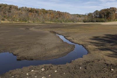 A small creek runs through a dry lake bed.