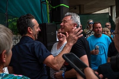 Two men having a conversation at an outdoor concert venue