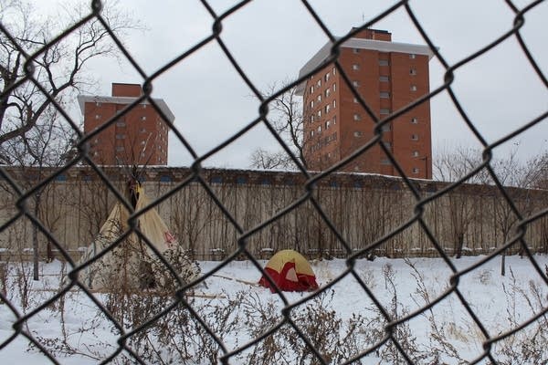 Tents sit behind a fence