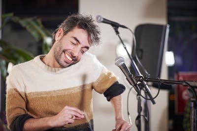 A man snaps his fingers and sings onstage