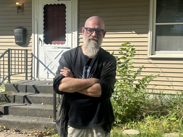 Man with beard and glasses poses for outside photo