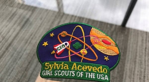 Sylvia Acevdeo's custom Girl Scout badge shows her three favorite math symbols: infinity, pi, and summation.