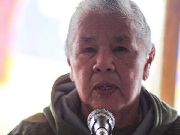 A veteran stands in front of a microphone to speak.