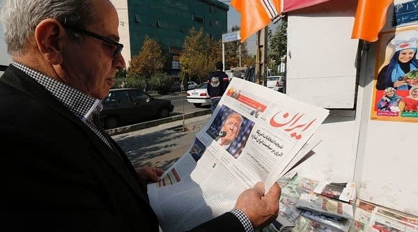 An Iranian man holds a local newspaper displaying a portrait of Donald Trump a day after his election as the new US president, in the capital Tehran, on November 10, 2016.
