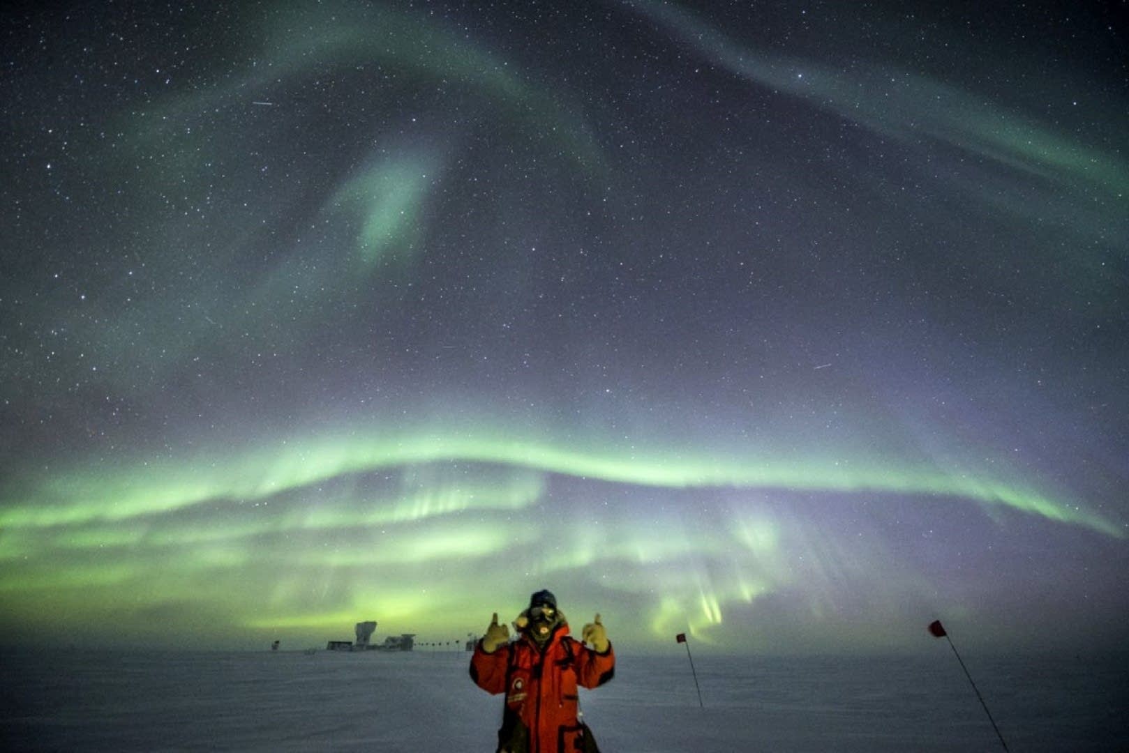 Robert Schwarz gives the thumbs up under bright auroras.