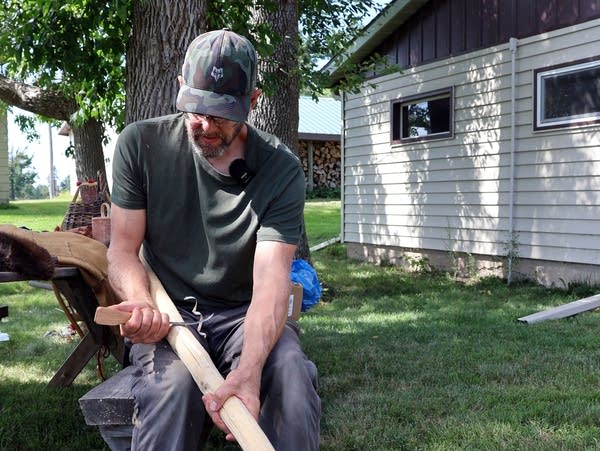 a man holds a wooden pole