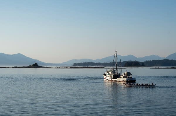 Two boats in the water with mountains in the background.