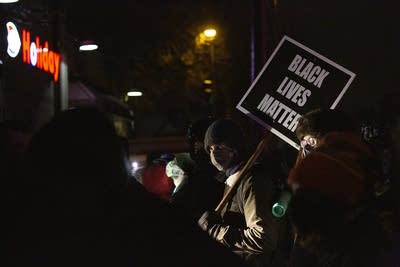 A person holds a sign in the street. 