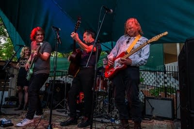 A rock band performing on an outdoor stage