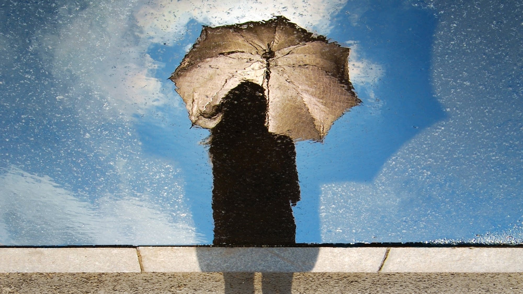 A reflection of a woman with an umbrella
