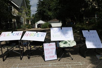 A line of lawn chairs with protest signs displayed on them.