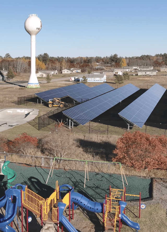 A view of a solar panel array near a playground.