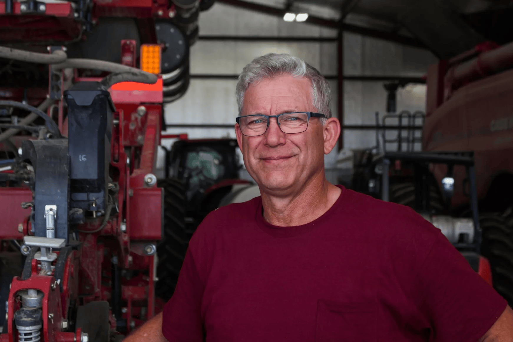 A man in a red shirt poses for a photo