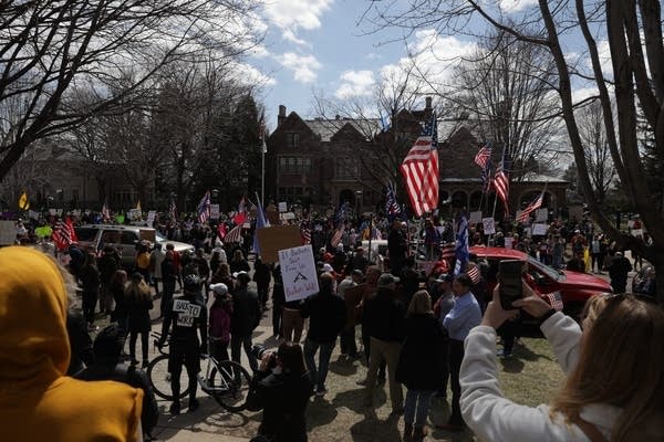 People gather to protest outside of the governor's residence