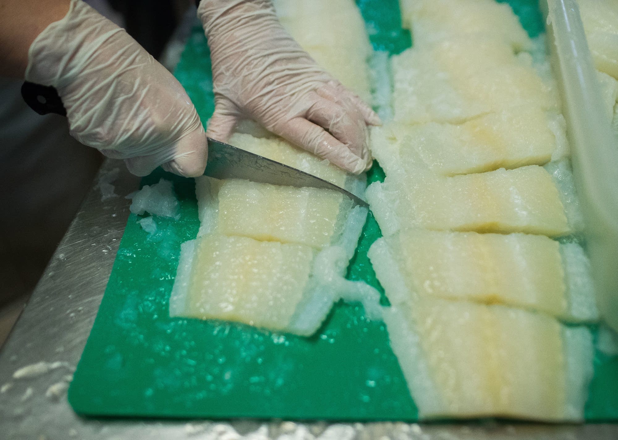 Catherine Anderson cuts lutefisk and puts it into bins.