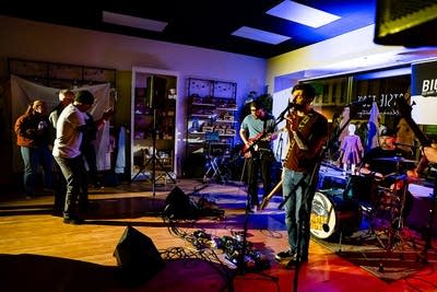 A band performing onstage as people dance