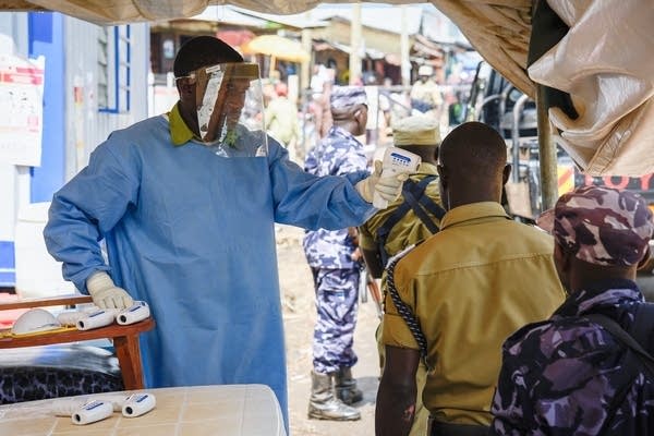 A medical assistant uses a non-contact thermometer to check the temperature of people from Democratic Republic of Congo (DRC) at the Ebola screening point bordering with DRC in Mpondwe, western Uganda. (Photo: ISAAC KASAMANI/AFP/Getty Images)