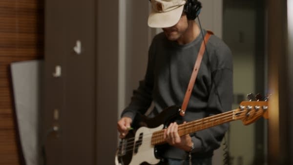 A bassist performing in a recording studio