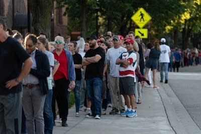 People wait in line to attend an event