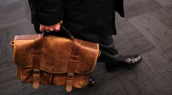 A job seeker carries a worn briefcase at the Green Jobs and Entrepeneurship Fair in Berkeley, California.