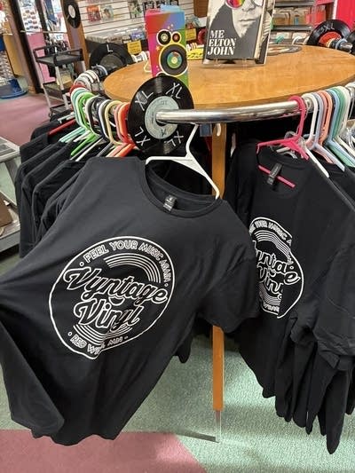 T-shirts emblazoned with the logo of a record store on display in said shop